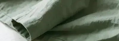 セージ色のリネンシーツの折り目